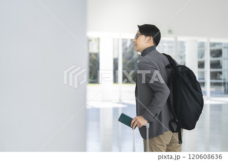 キャリーバッグとスマホを持って歩く40代の男性 キャリーバッグとスマホを持って歩く40代の男性 120608636