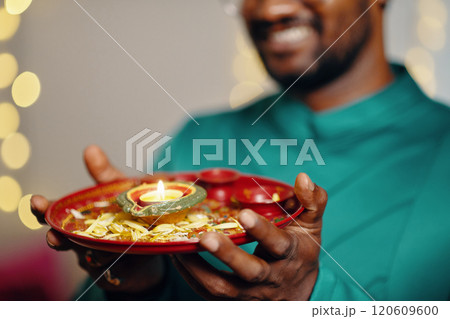 Holding Traditional Indian Oil Lamp During Religious Ceremony Holding Traditional Indian Oil Lamp During Religious Ceremony 120609600