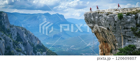 Adventurous Hikers Enjoying View on Mountain Cliff Overlooking Valley and Blue Sky 120609807