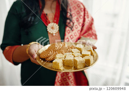 Holding Assorted Indian Sweets on Golden Plate Holding Assorted Indian Sweets on Golden Plate 120609948
