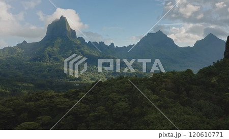 Scenic aerial perspective of green rainforest blanketing the rugged volcanic mountains peaks, stunning panorama of Moorea tropical island in French Polynesia. Remote wild nature travel background Scenic aerial perspective of green rainforest blanketing the rugged volcanic mountains peaks, stunning panorama of Moorea tropical island in French Polynesia. Remote wild nature travel background 120610771