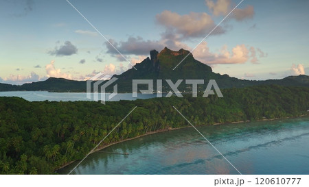 Bora Bora tropical paradise aerial landscape, breathtaking perspective of mount Otemanu, crystal lagoon, palm tree forest under gorgeous pink hues sunset. Explore French Polynesia travel destination 120610777