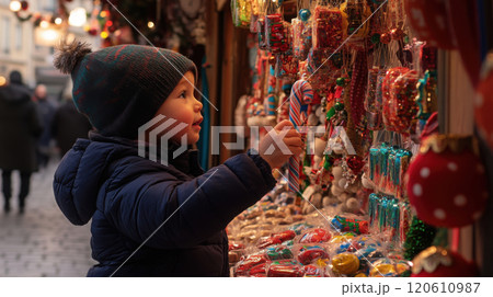 Child admiring colorful candy cane at holiday market stall 120610987