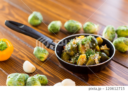 Brussel sprouts cooked with vegetables and spices, on a wooden table 120612715