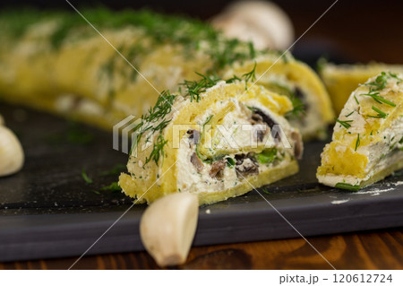 baked potato roll with cottage cheese filling with garlic and mushrooms, on a dark wooden table baked potato roll with cottage cheese filling with garlic and mushrooms, on a dark wooden table 120612724