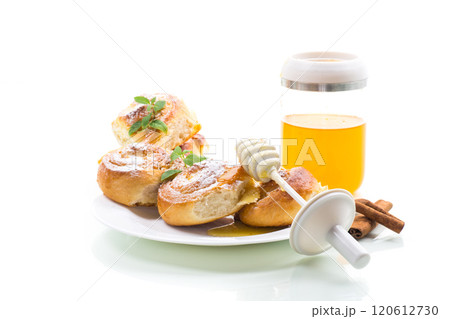 Baked goods. Sweet buns with cottage cheese filling and honey in a plate isolated on a white background Baked goods. Sweet buns with cottage cheese filling and honey in a plate isolated on a white background 120612730