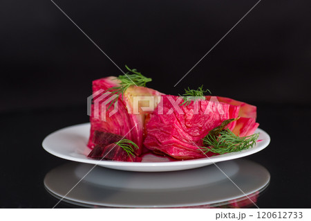 pickled cabbage with beets and carrots, in a plate, isolated on black background 120612733