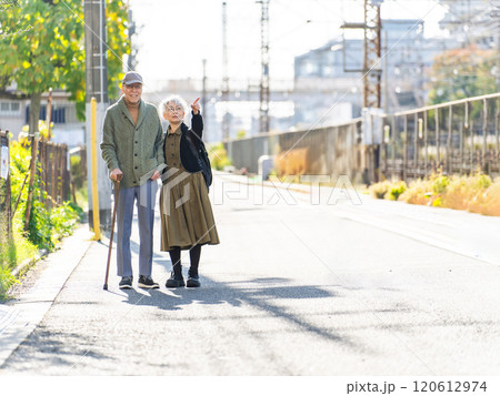 寄り添って街を歩くシニアカップル 120612974