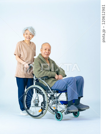 車椅子に乗ったシニア男性と介助する女性介護士 車椅子に乗ったシニア男性と介助する女性介護士 120612981