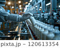Selective focus of A robot arm in a dairy factory is picking up a stack of white glass bottles filled with fresh pasteurized milk. 120613354