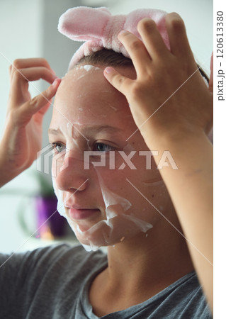 girl with a cosmetic mask on her face 120613380