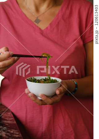 Girl holding a cup of wakame in her hands Girl holding a cup of wakame in her hands 120613403