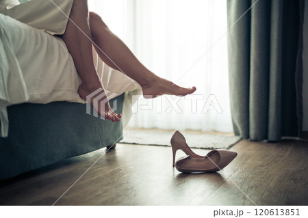 Womans feet in white bathrobe lying on sofa and relaxing at the room 120613851