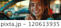 Caucasian woman showing car keys in hand sitting inside car in showroom. 120613935