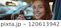 Caucasian woman showing car keys in hand sitting inside car in showroom. 120613942