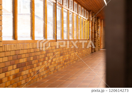 Empty school hallway with brick walls and large windows, bright and clean Empty school hallway with brick walls and large windows, bright and clean 120614273
