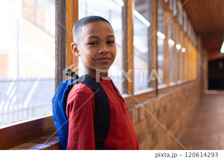 Smiling boy with backpack standing in school hallway, looking at camera Smiling boy with backpack standing in school hallway, looking at camera 120614293