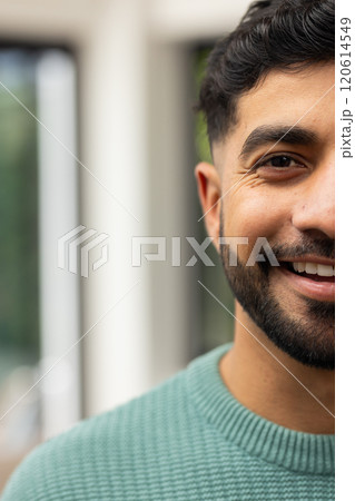 Smiling Indian man in green sweater enjoying time indoors, close-up portrait, copy space Smiling Indian man in green sweater enjoying time indoors, close-up portrait, copy space 120614549