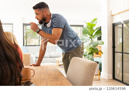 Start up business, Man leaning on table, talking to friends in casual home setting Start up business, Man leaning on table, talking to friends in casual home setting 120614596