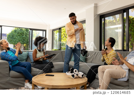 Friends enjoying VR gaming together, laughing and having fun in living room Friends enjoying VR gaming together, laughing and having fun in living room 120614685
