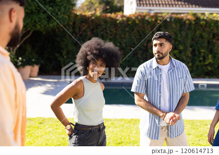 diverse friends talking and enjoying outdoor gathering by pool on sunny day 120614713
