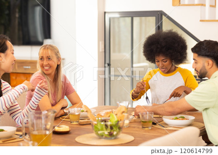 Eating lunch together, group of young diverse friends enjoying meal at home 120614799