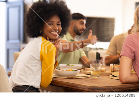 Enjoying meal with diverse friends, smiling woman socializing at dining table 120614809
