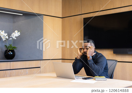 Stressed african american businessman in office holding head while working on laptop, copy space 120614888