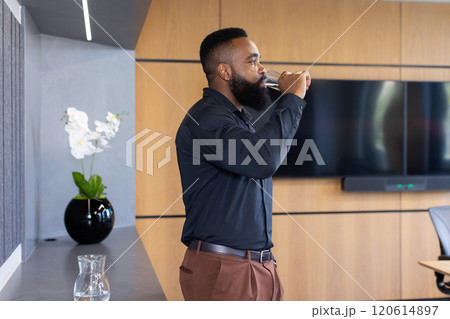 Drinking water, african american businessman taking break in modern office conference room Drinking water, african american businessman taking break in modern office conference room 120614897