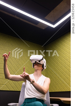 Using VR headset, businesswoman interacting with virtual environment in office 120615458