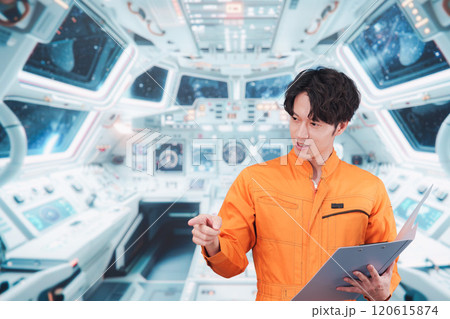 宇宙ステーションの中で働く若い男性の宇宙飛行士 120615874