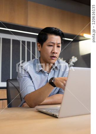 Working on laptop, asian man in office focusing on business tasks 120616135