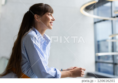 Smiling woman leaning on railing, enjoying break in modern office building, copy space 120616201