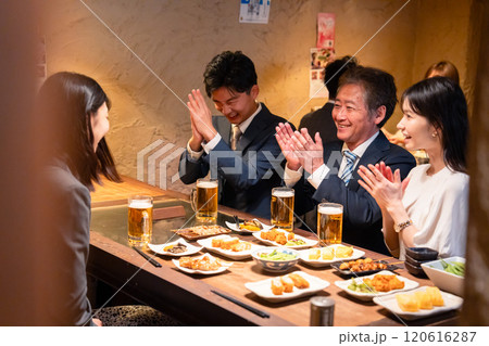 居酒屋でお祝いをするビジネスパーソン 120616287