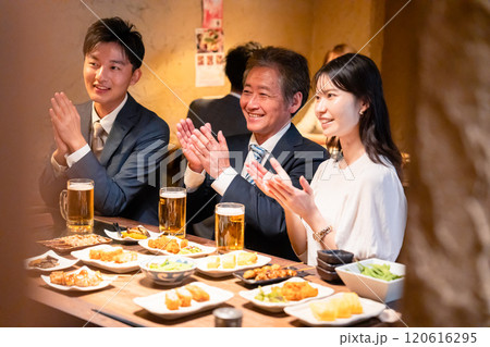 居酒屋でお祝いをするビジネスパーソン 居酒屋でお祝いをするビジネスパーソン 120616295
