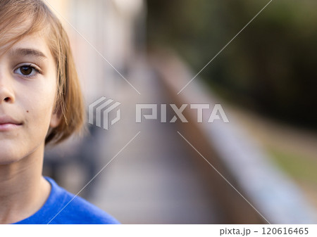 In school, boy standing outside, looking at camera with serious expression, copy space 120616465