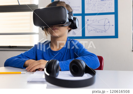 Using VR headset, boy in school exploring virtual reality in classroom Using VR headset, boy in school exploring virtual reality in classroom 120616508