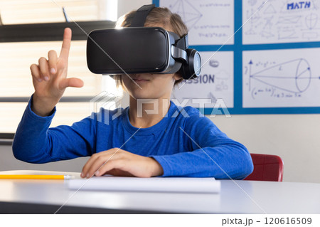 Using VR headset, boy in school exploring virtual reality in classroom Using VR headset, boy in school exploring virtual reality in classroom 120616509