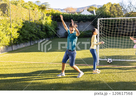 Playing soccer, boy celebrating goal with friends on outdoor field, copy space Playing soccer, boy celebrating goal with friends on outdoor field, copy space 120617568