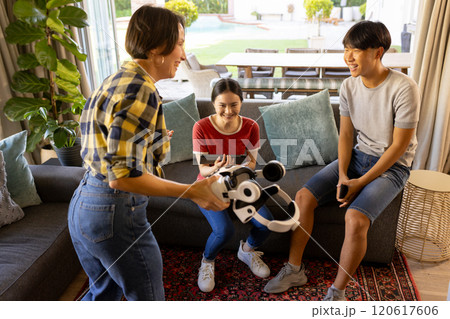 Playing with VR headset, family enjoying time together in living room 120617606