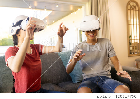 Playing with VR headsets, two people enjoying virtual reality experience indoors 120617750