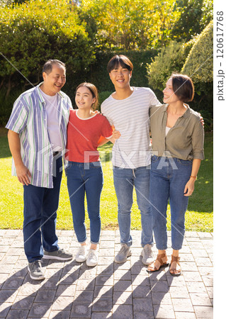 Smiling family standing together outdoors, enjoying quality time in garden 120617768