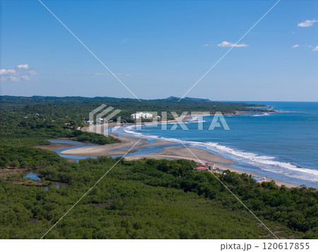 Scenic coastal view showcasing lush greenery and waves along serene beach 120617855
