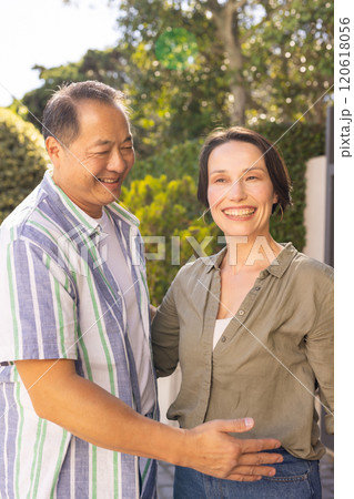 Smiling couple standing outdoors, enjoying quality time together in garden 120618056