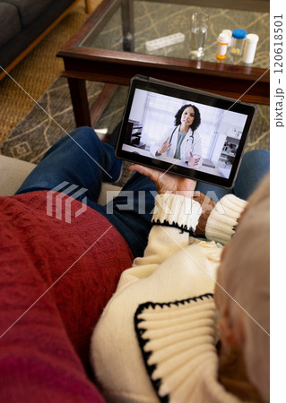 Caucasian senior couple having video call with doctor in sunny living room Caucasian senior couple having video call with doctor in sunny living room 120618501
