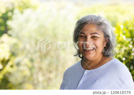 Portrait of happy biracial senior woman laughing in sunny garden, copy space Portrait of happy biracial senior woman laughing in sunny garden, copy space 120618579