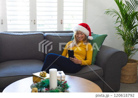 Happy caucasian woman in santa hat having video call and smiling at christmas at home Happy caucasian woman in santa hat having video call and smiling at christmas at home 120618792