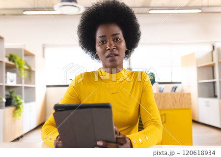 Portrait of african american casual businesswoman having video call in creative office Portrait of african american casual businesswoman having video call in creative office 120618934