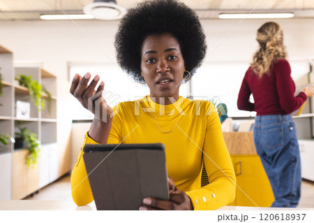 Portrait of african american casual businesswoman having video call in creative office Portrait of african american casual businesswoman having video call in creative office 120618937
