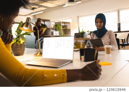 African american casual businesswoman using laptop with copy space in creative office 120618946